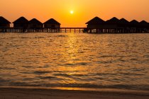 Silhouette of wooden bungalows in sea water, Maldives — Stock Photo