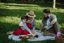 Familia con un niño haciendo un picnic - foto de stock