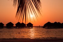 Silhouette of wooden bungalows in sea water, Maldives — Stock Photo
