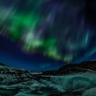 Vista panorámica de las luces boreales sobre las montañas, Islandia - foto de stock
