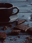 Closeup view of black cup of coffee with chocolate — Stock Photo