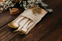 Close-up view of gold cutlery on wooden table — Stock Photo