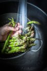 Man hand rinsing asparagus in water — Stock Photo