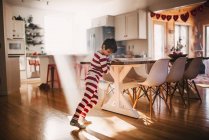 Хлопчик танцює на кухні в піжамах — стокове фото