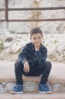 Портрет улыбающегося мальчика, сидящего на ступеньке, Малага, Андалусия, Испания — стоковое фото