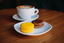 Vista ravvicinata della tazza di caffè con due macaron — Foto stock