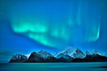 Vista panorámica de las luces boreales sobre las montañas, Myrland, Flakstad, Nordland, Noruega - foto de stock