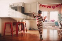Menino dançando na cozinha em seu pijama — Fotografia de Stock