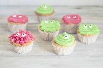 Nahaufnahme von Monster-Cupcakes über Holztisch — Stockfoto