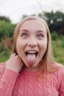 Retrato de uma menina salientando a língua — Fotografia de Stock