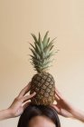 Donna che tiene un ananas in testa — Foto stock