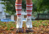 Primer plano de las piernas de una chica con patines y calcetines largos - foto de stock