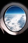 Scenic view through an airplane window on clouds — Stock Photo