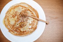 Teller mit Crêpes mit Honig und einem Honigtröpfchen — Stockfoto
