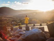 Boy standing on wooden post in a rural landscape, Orange County, California, United States — Stock Photo