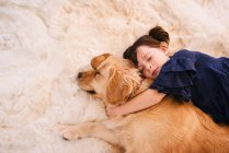 Дівчина спить на килимку зі своїм золотим собакою-ретривером — стокове фото
