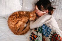 Young girl sleeping on bed with cat — Stock Photo