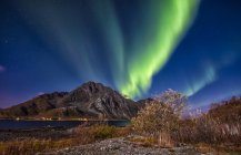 Aurora boreal sobre el monte. Tienda Nappstind, Lofoten, Nordland, Noruega - foto de stock