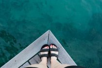 Primo piano dei piedi di una donna in piedi sul bordo di un molo di legno, Tahiti, Polinesia francese — Foto stock