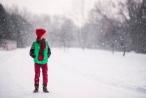 Junge steht an einem Wintertag im Schnee — Stockfoto