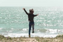 Девочка на пляже прыгает в воздух, Испания — стоковое фото