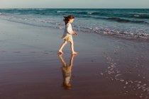 Mädchen am Strand zu Fuß in Richtung Meer, Spanien — Stockfoto
