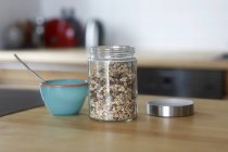 Jar of muesli and a  bowl on a kitchen table — Stock Photo