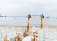 Свадебная церемония с цветами и свечами на пляже — стоковое фото