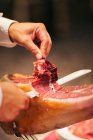 Шеф-кухар, що ріже м'ясо прошутто, обрізаний постріл — стокове фото
