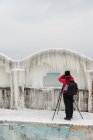 Mulher fotografando icicles em uma parede à beira-mar, Bulgária — Fotografia de Stock