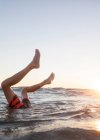 Boy's legs sticking out of the ocean, Orange County, United States — Stock Photo