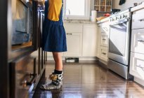 Ноги дівчини стоять на кухні — стокове фото