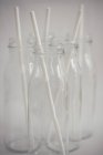 Closeup view of Five glass bottles with drinking straws — Stock Photo