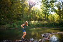 Donna che cammina lungo una riva del fiume — Foto stock