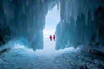 Zwei Frauen vor einer mit Eiszapfen bedeckten Höhle, Oblast Irkutsk, Sibirien, Russland — Stockfoto