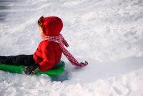 Garçon luge dans la neige sur la nature — Photo de stock