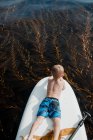Boy lying down on a paddleboard, Orange County, Califórnia, Estados Unidos — Fotografia de Stock