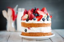 Sponge cake with strawberries, blueberries and cream — Stock Photo