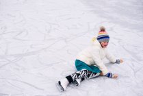Menina que caiu sobre a patinação no gelo — Fotografia de Stock