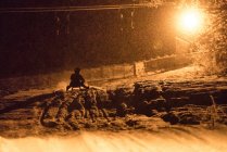 Silhouette of a man sledging at night, Zauchensee, Salzburg, Austria — Stock Photo