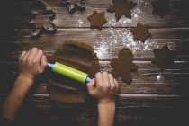 Boy making gingerbread cookies, rolling out cookie dough — Stock Photo