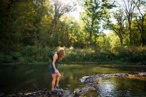 Donna che cammina lungo una riva del fiume — Foto stock