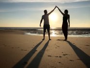 Silhouette d'un homme et d'une femme sur une plage, Pointe Espagnole, La Tremblade, Charente-Maritime, France — Photo de stock