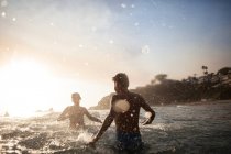 Two boys playing in the surf, Orange County, California, United States — Stock Photo