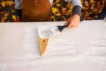 Garçon peignant une décoration fantôme en bois pour Halloween — Photo de stock
