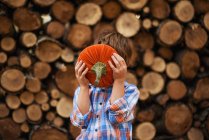 Boy holding a pumpkin in front of his face — Stock Photo