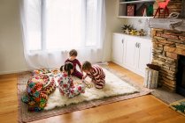 Троє дітей сидять на підлозі граючи в настільну гру — стокове фото