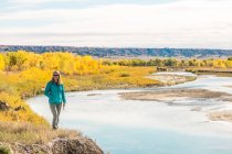 Donna in piedi lungo un fiume in autunno, Dakota del Sud, America, Stati Uniti — Foto stock