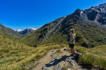 Escursionista in pausa acquatica, Rees Saddle, Rees-Dart Track, Mt Aspiring National Park, South Island, Nuova Zelanda — Foto stock