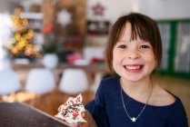 Menina segurando um biscoito de Natal — Fotografia de Stock